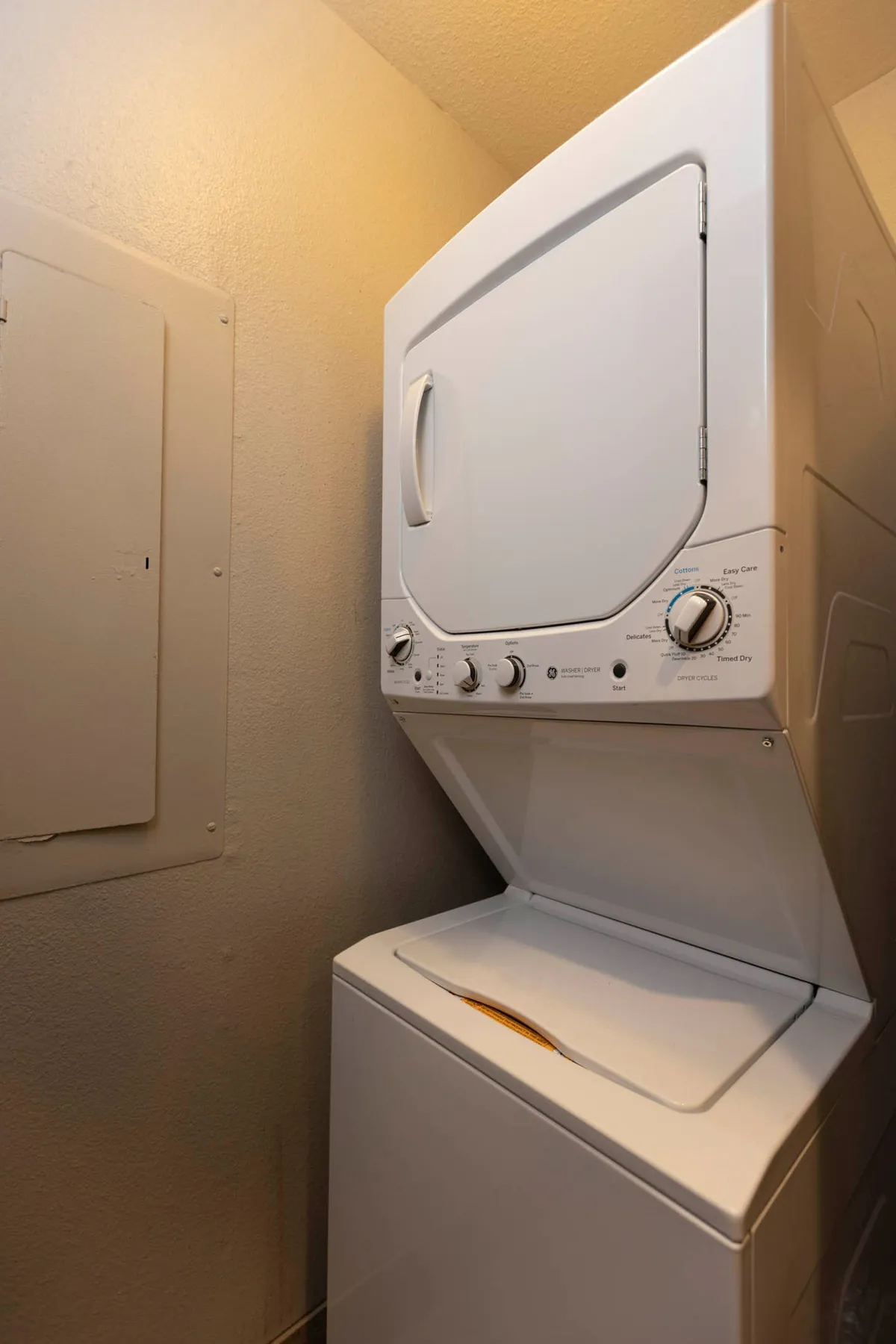 An interior view of stacked washer and dryer units in a dedicated laundry space. The area is clean, practical, and adds an element of convenience for guests staying longer or with families.